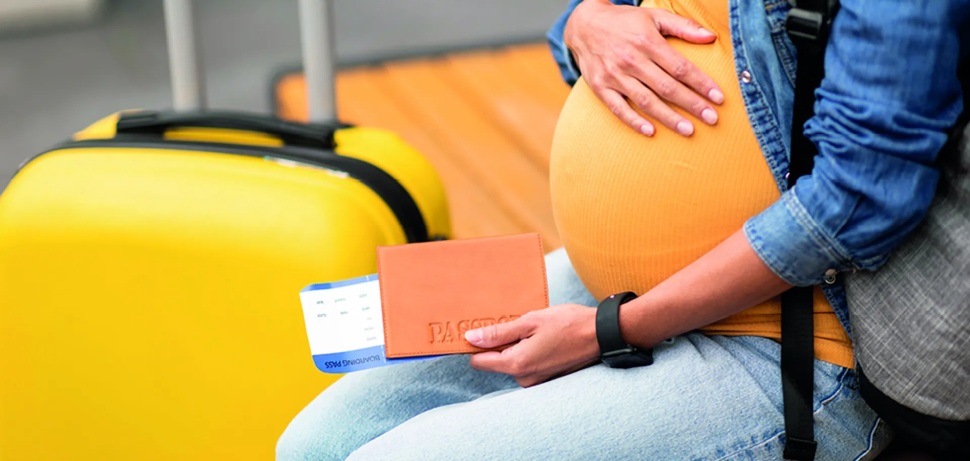 Femme enceinte avec une valise et un billet 
