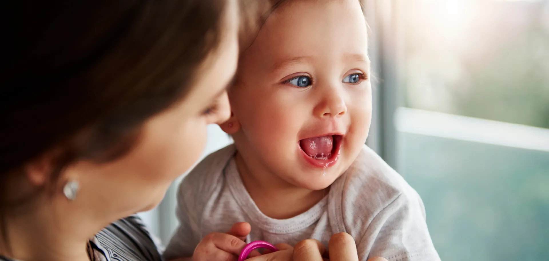 Bébé qui ouvre la bouche dans les bras d'une femme