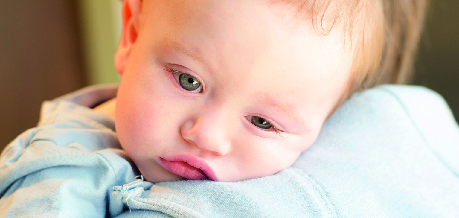 Bébé malade dans les bras d'un adulte
