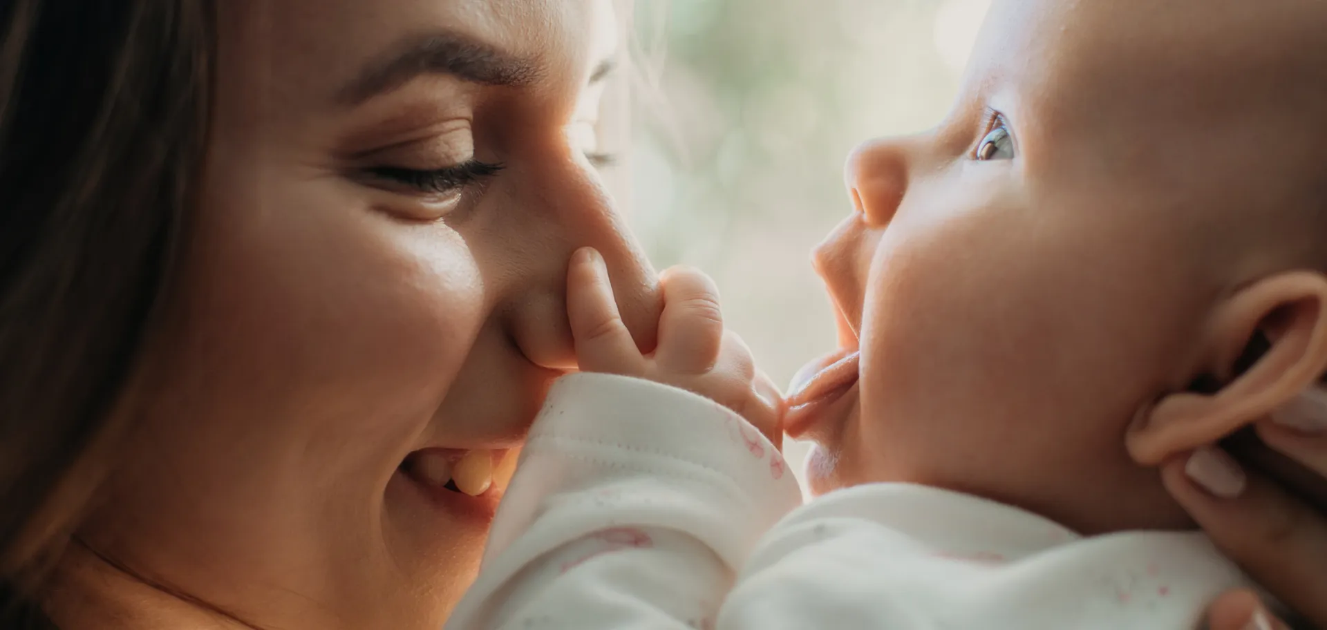 Maman souriante avec son bébé dans les bras