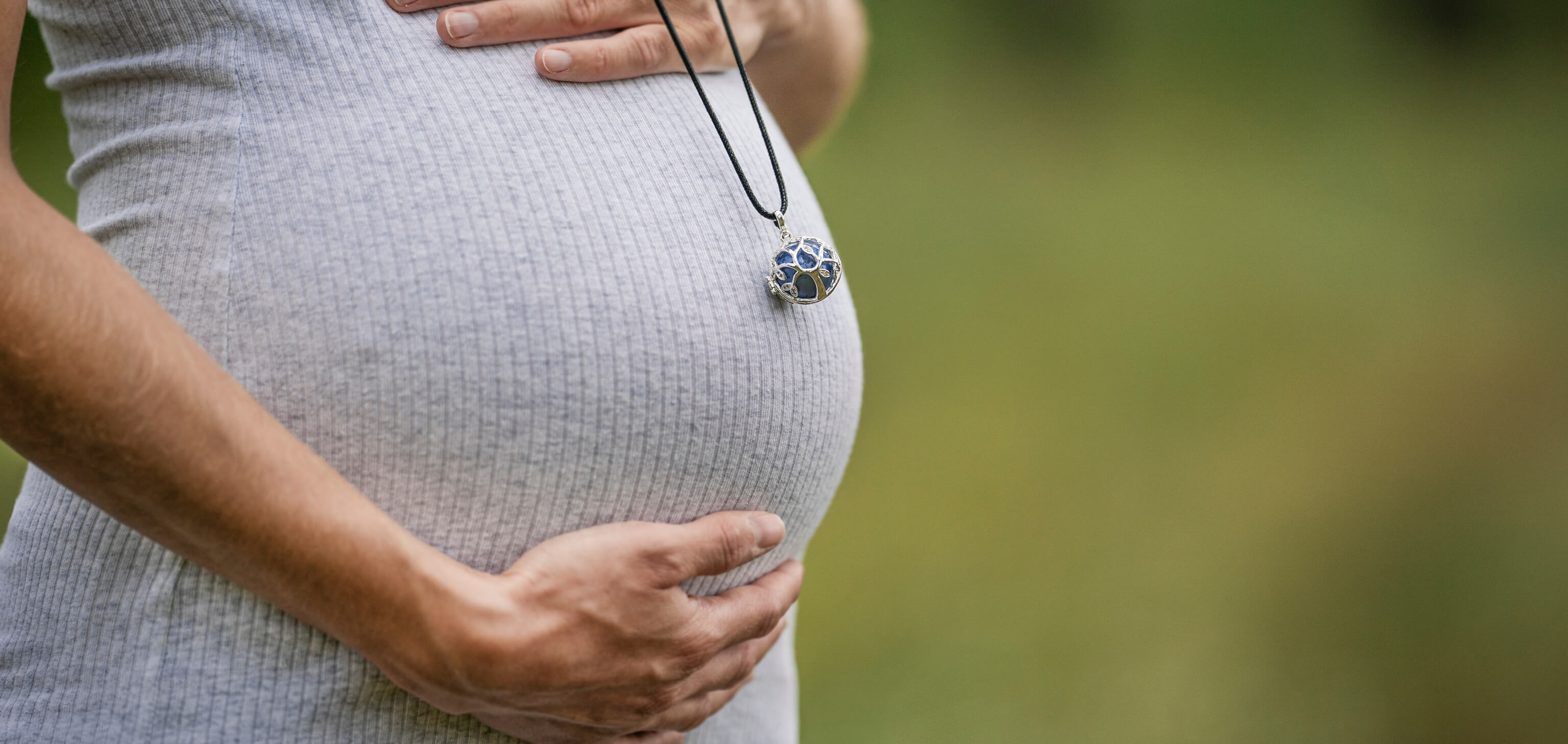 Ventre de femme enceinte avec pendentif bola
