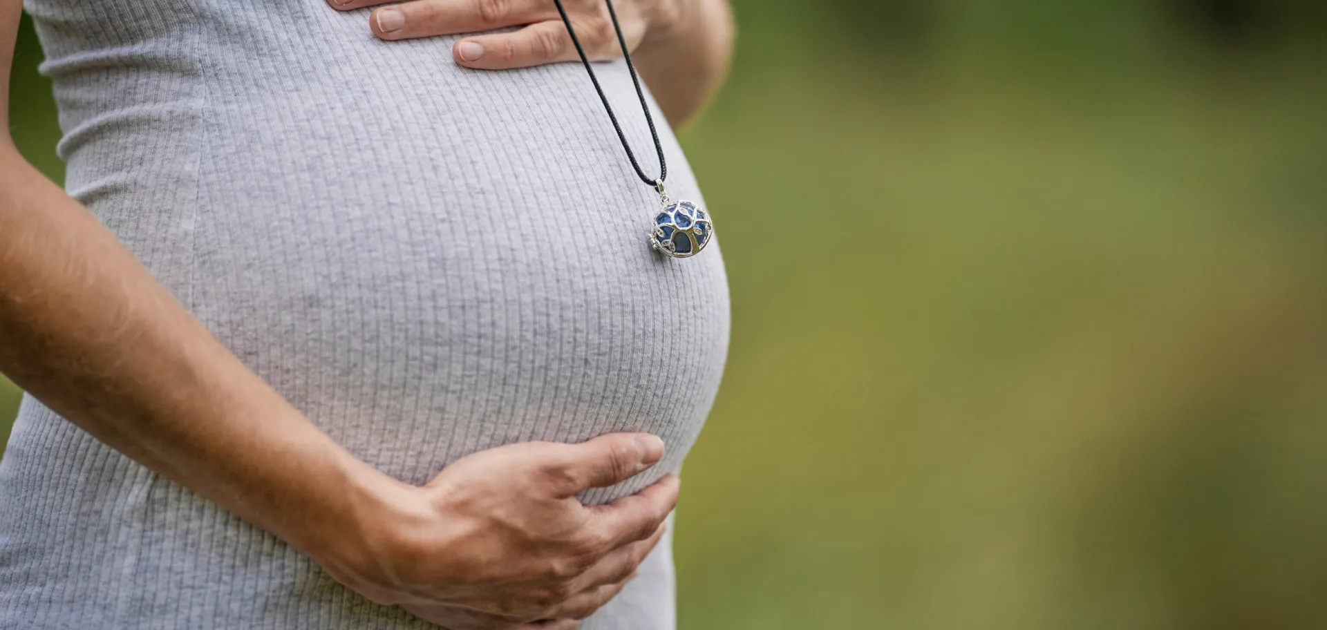 Ventre de femme enceinte avec pendentif bola