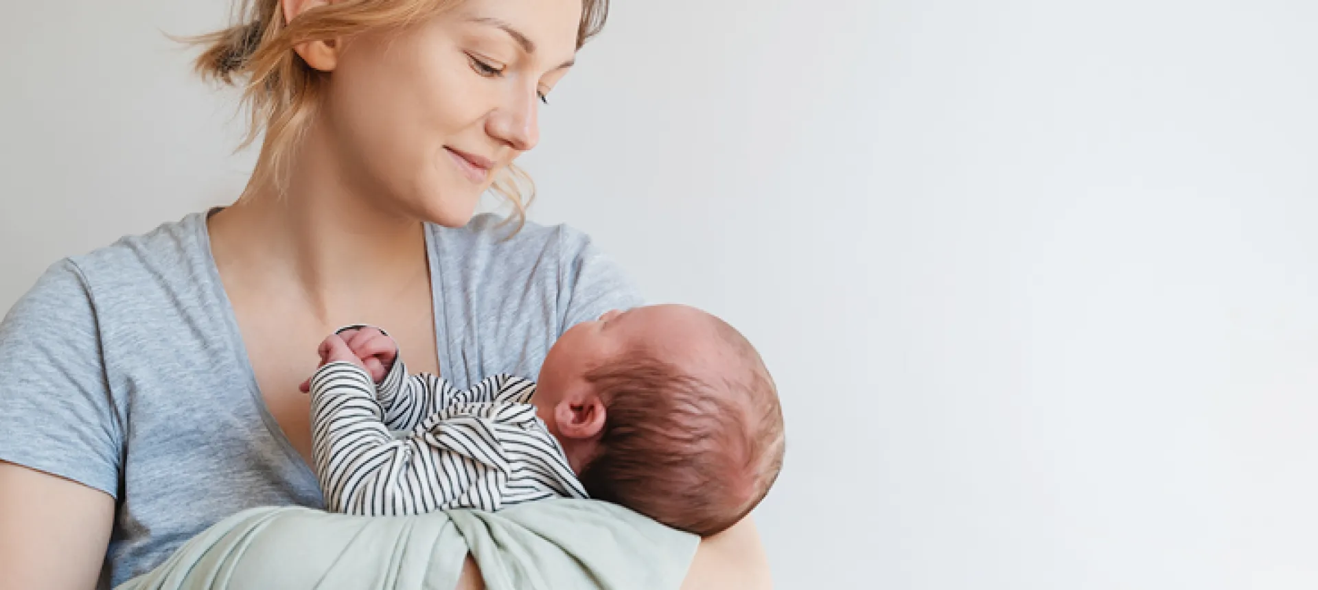 bébé endormi dans les bras de sa mère