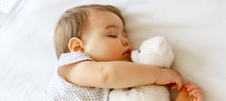 bébé qui dort avec un doudou