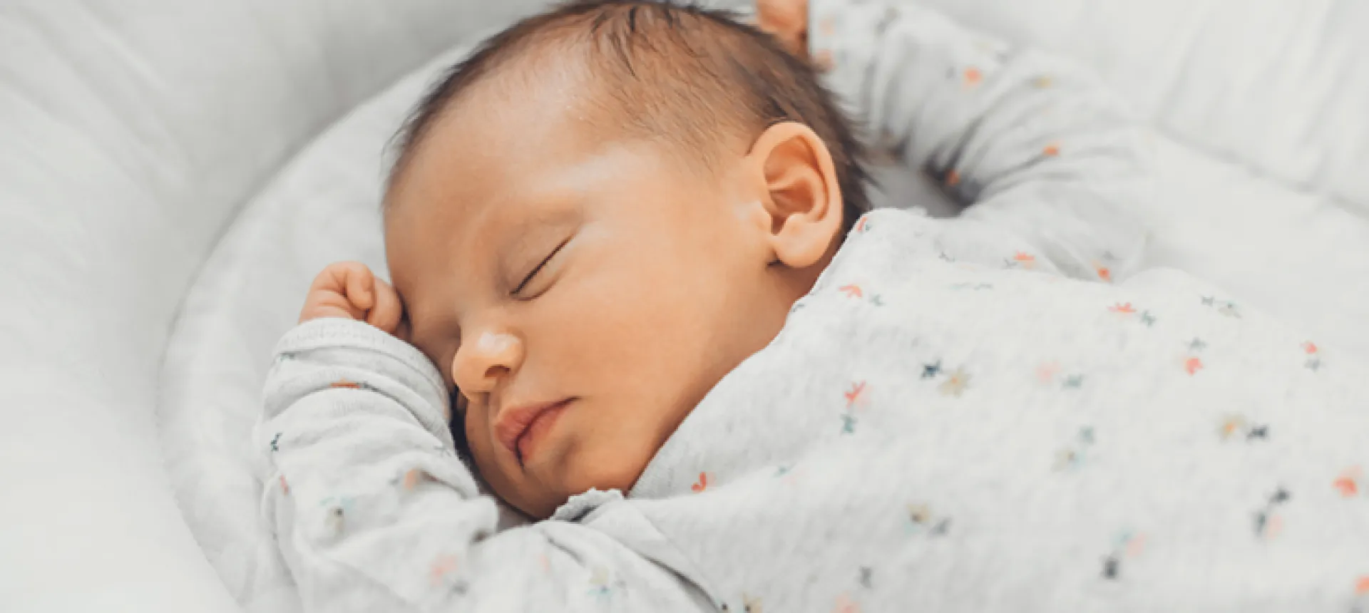 Nouveau né qui dort dans son lit