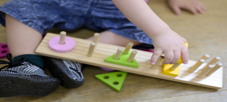 enfant qui joue avec un jeu en bois