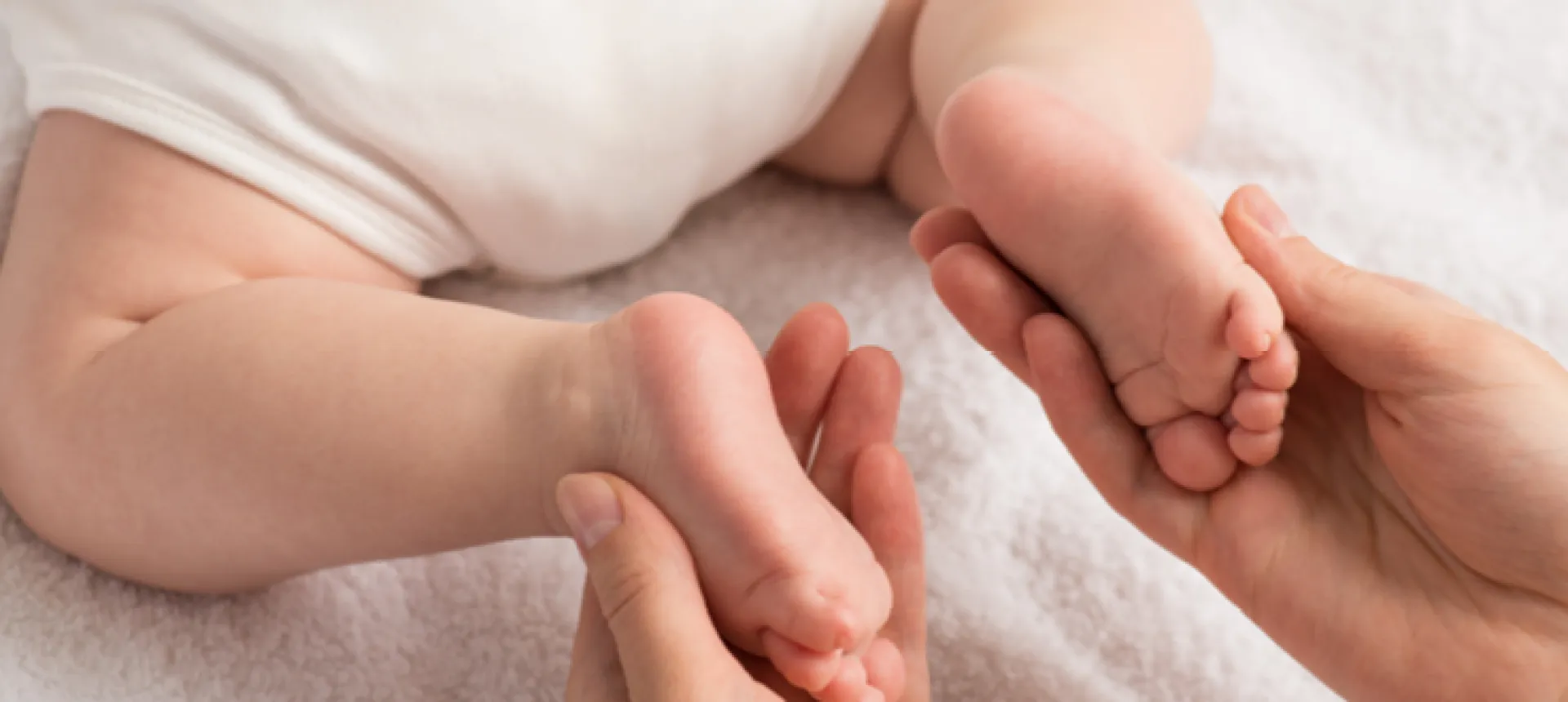 mains qui touchent pieds bébé