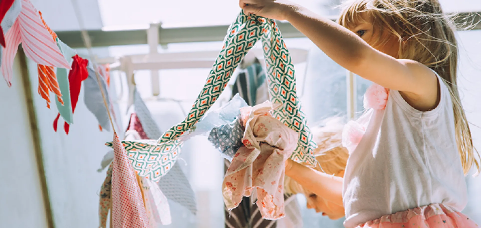 Petite fille jouant avec plusieurs tissus colorés