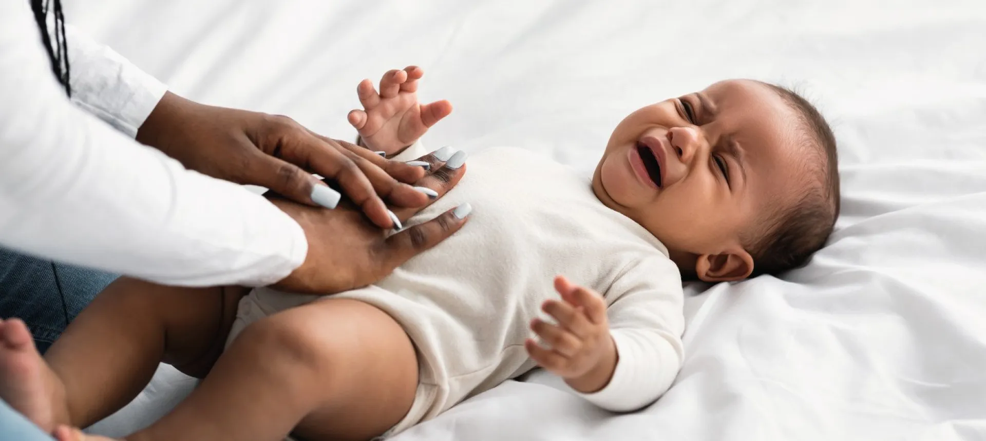 Femme masant le ventre d'un bébé en pleur