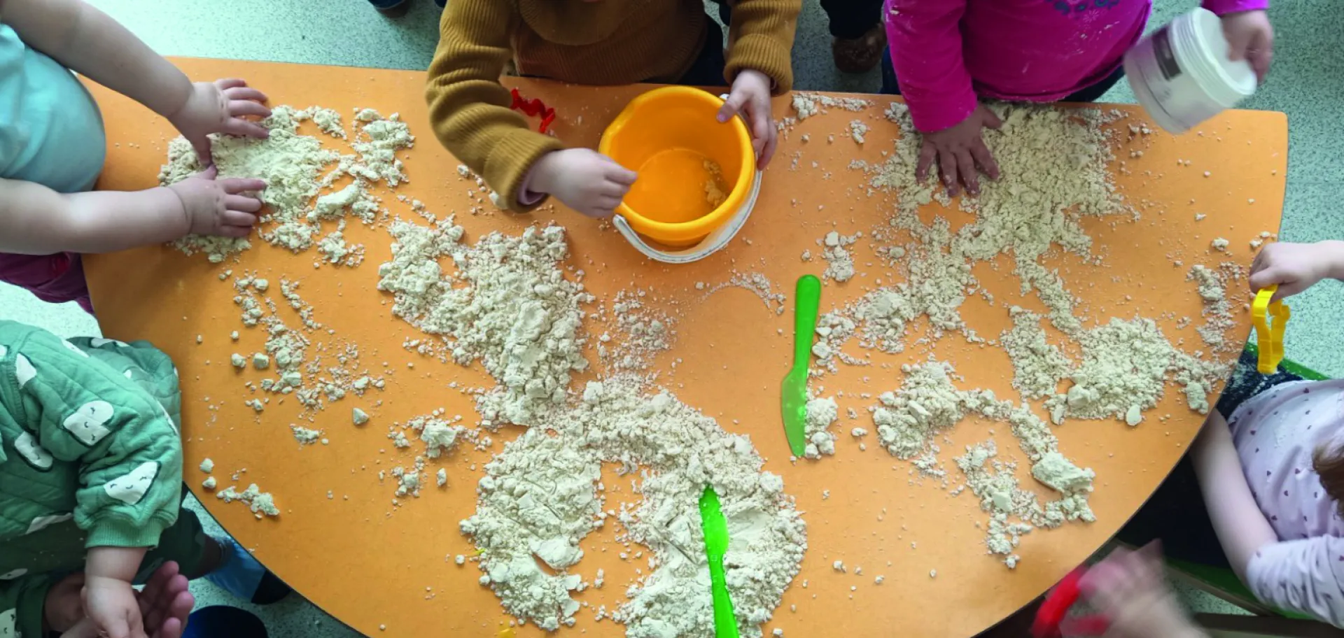 enfants autour d'une table touchant du sable