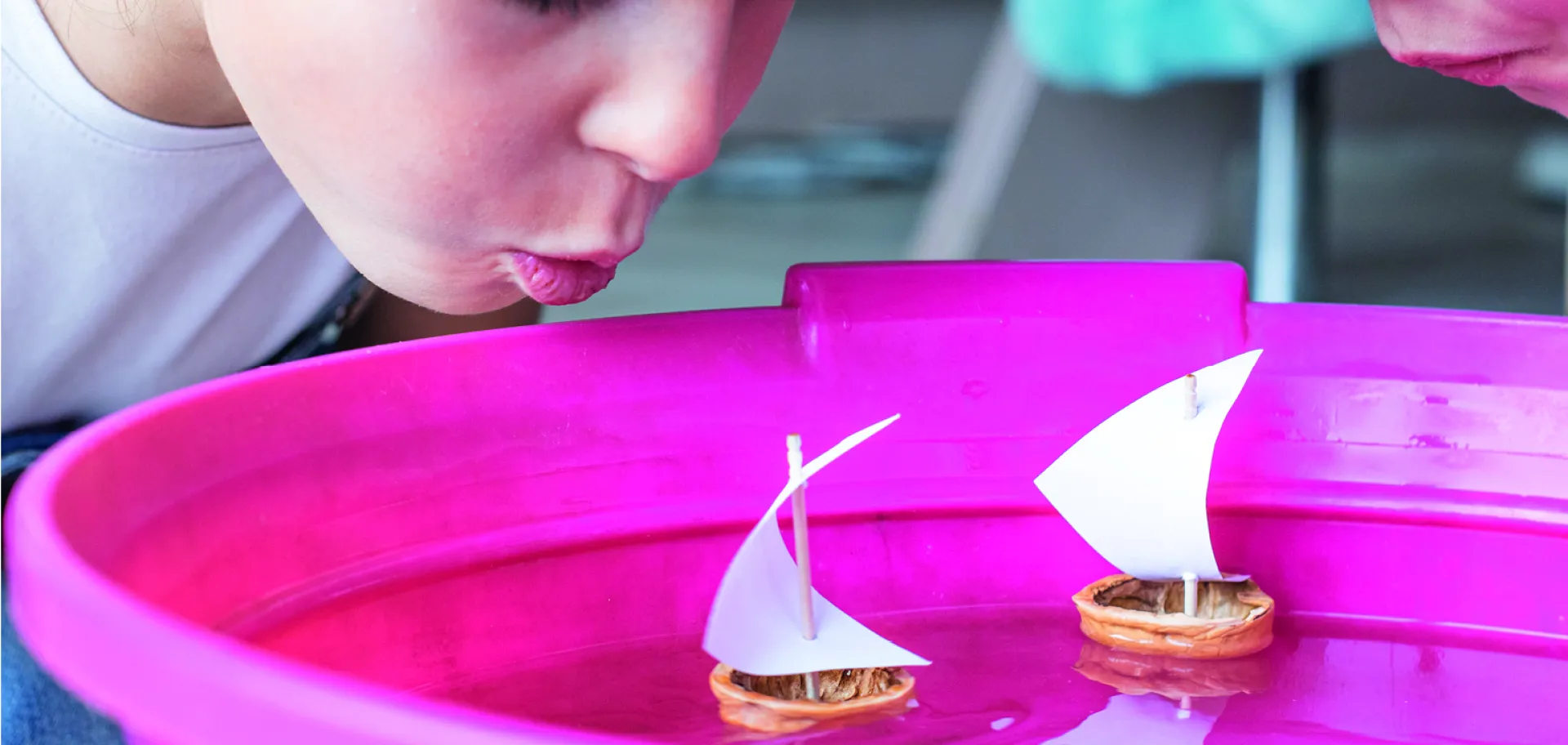 Enfant souffle sur un bateau en coquille de noix