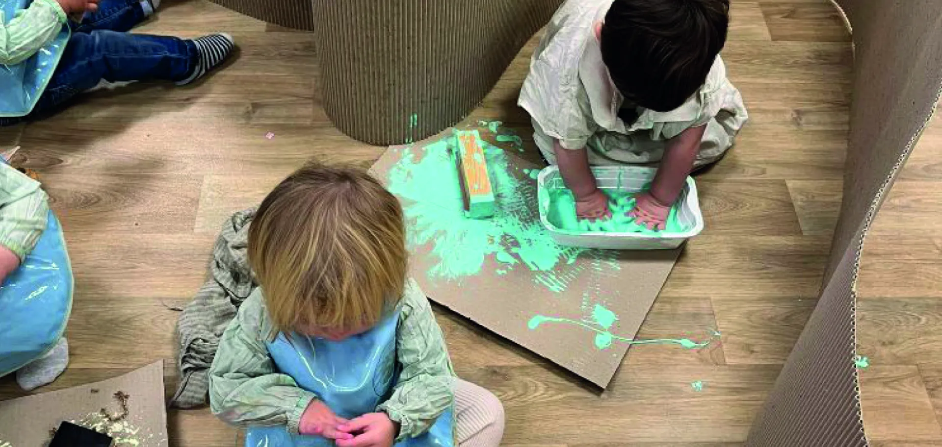 Enfants en crèche faisant de la peinture sur carton