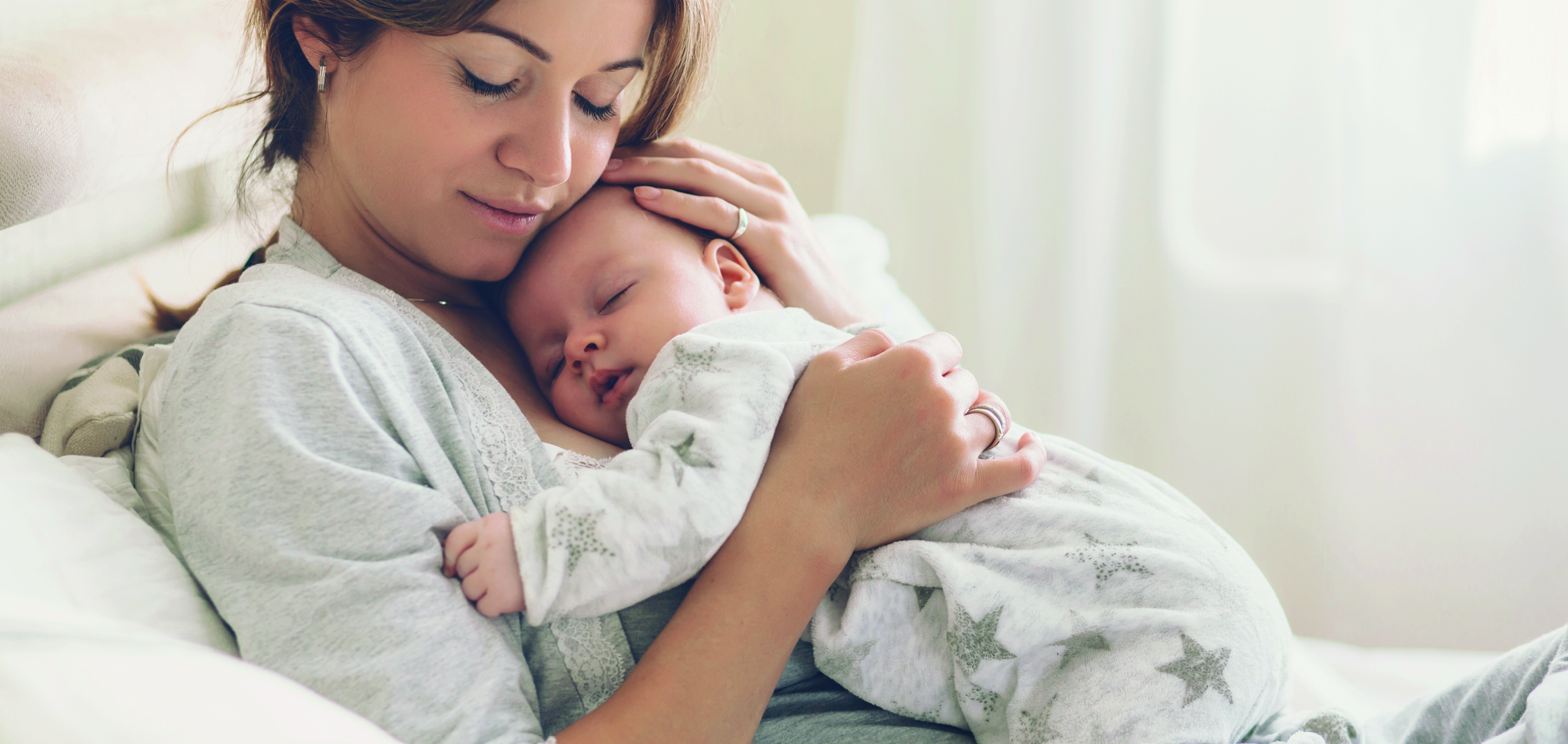 Bébé endormi dans les bras de sa maman