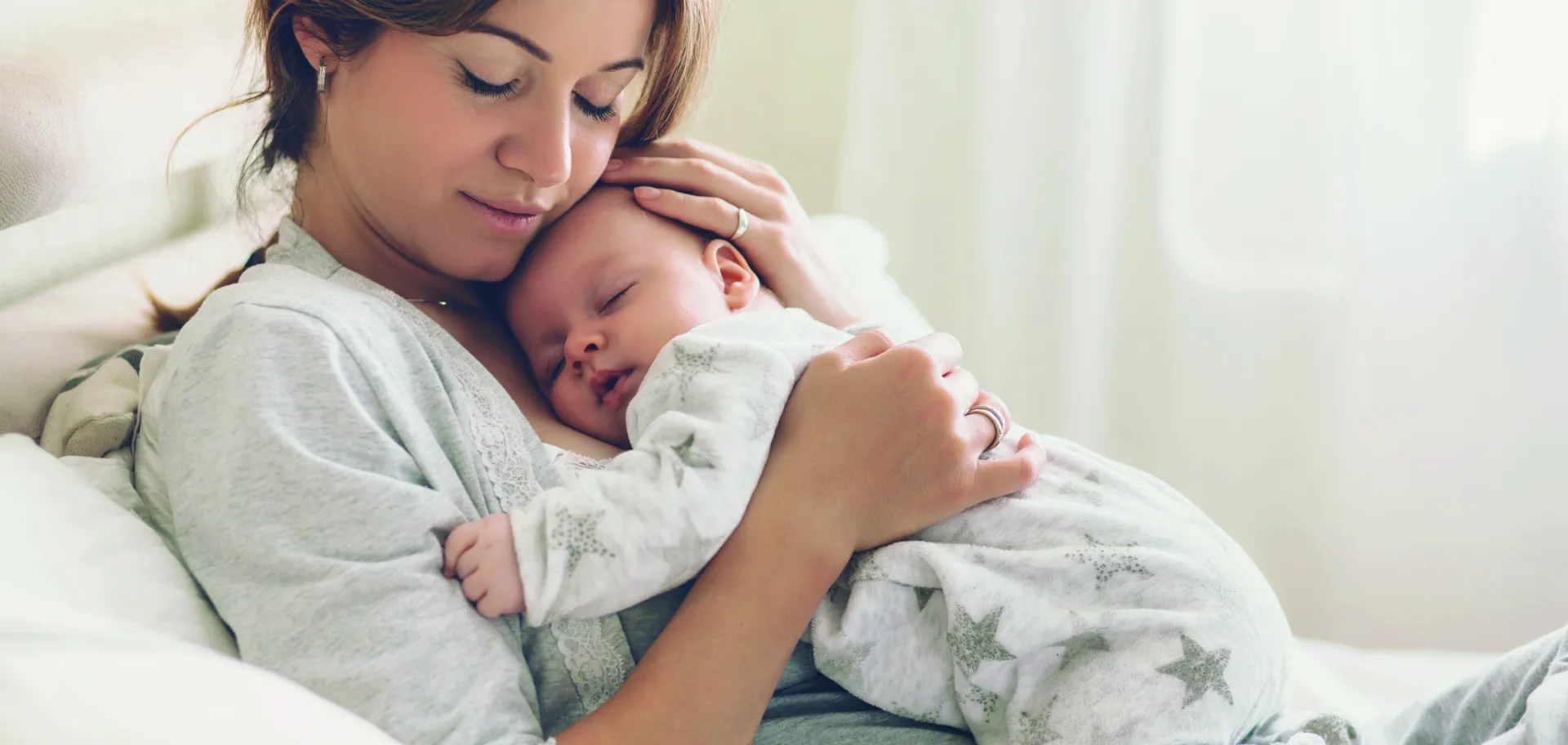 Bébé endormi dans les bras de sa maman