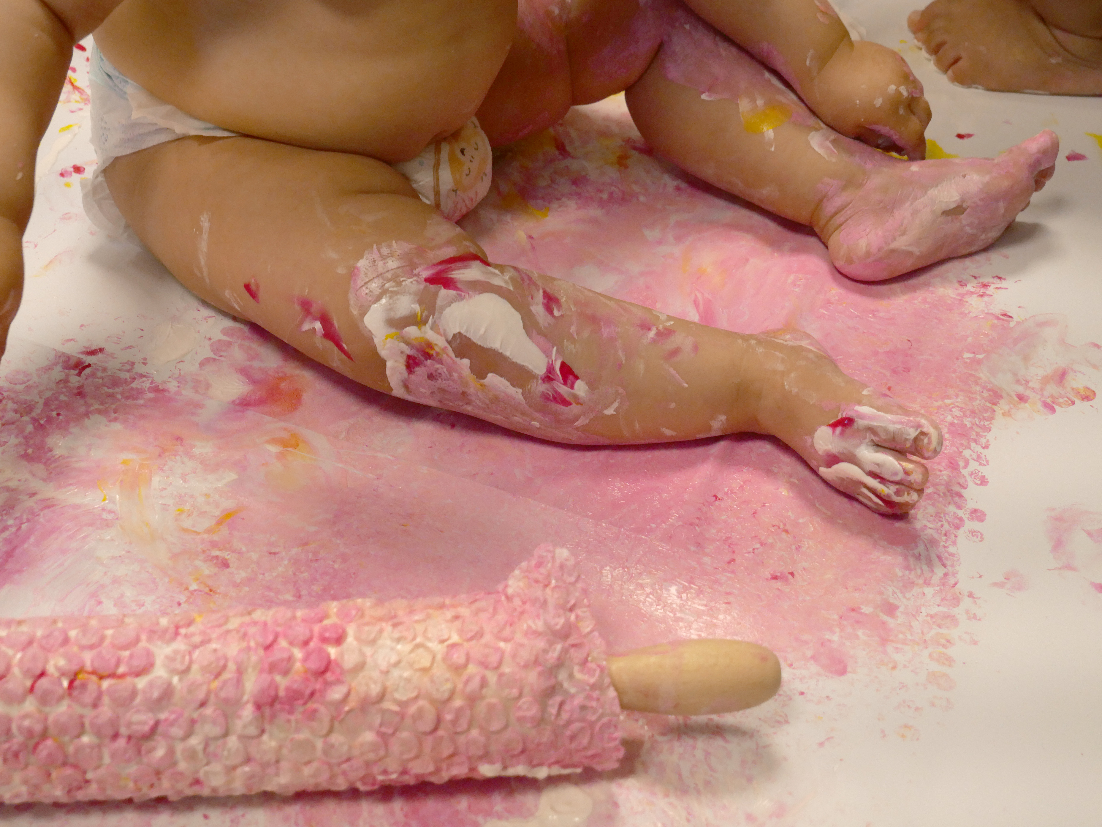 enfant avec un rouleau recouvert de peinture et papier bulle 
