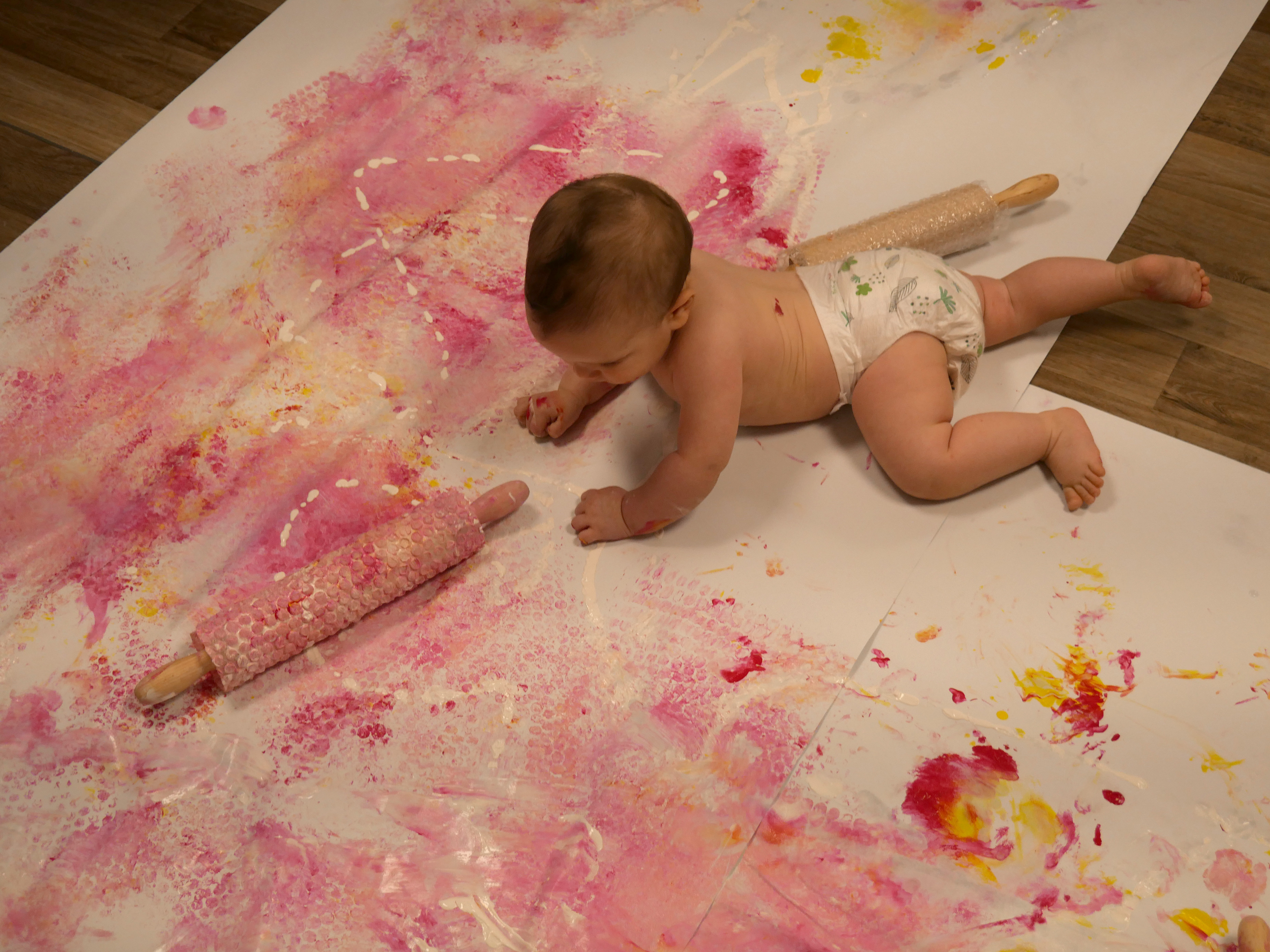 enfant avec un rouleau recouvert de peinture et papier bulle 