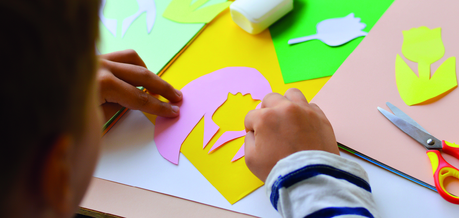enfant découpant des formes en papier
