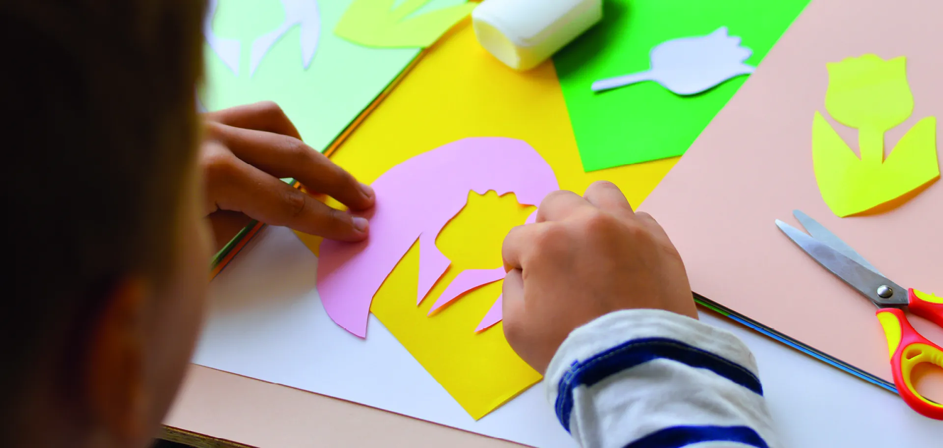 enfant découpant des formes en papier