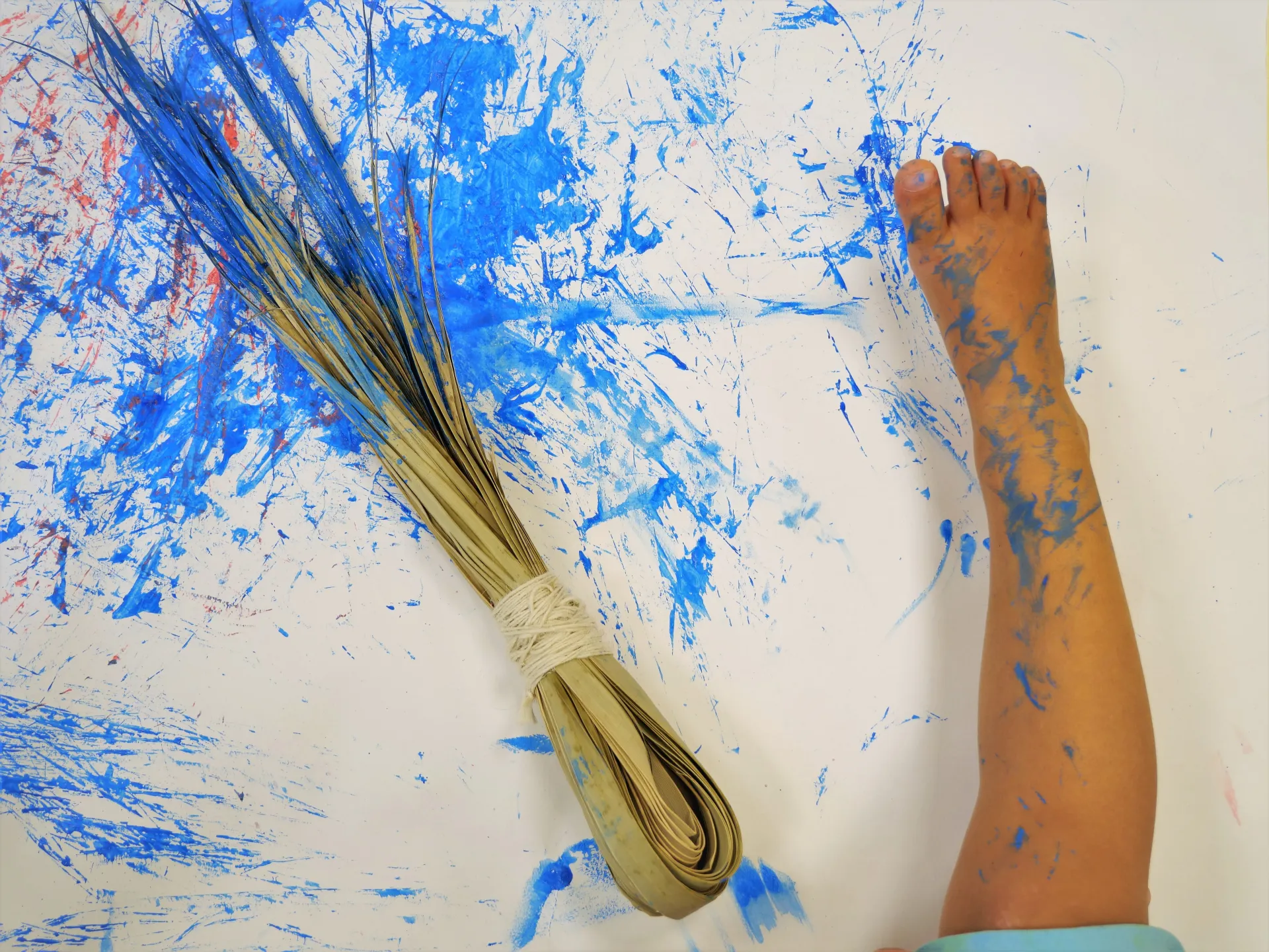 enfant tenant une branche de palmier avec peinture