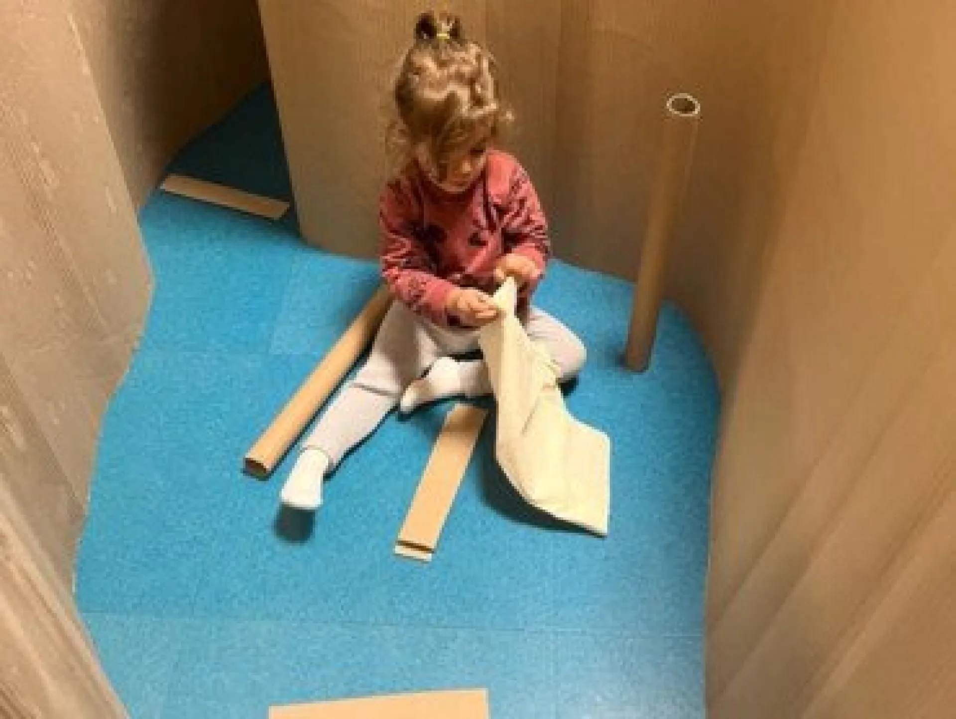 Enfant jouant dans structure carton
