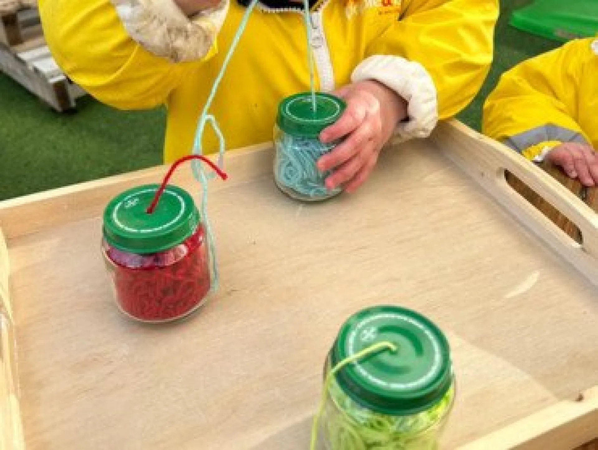 Activité enfant laine dans petit pot
